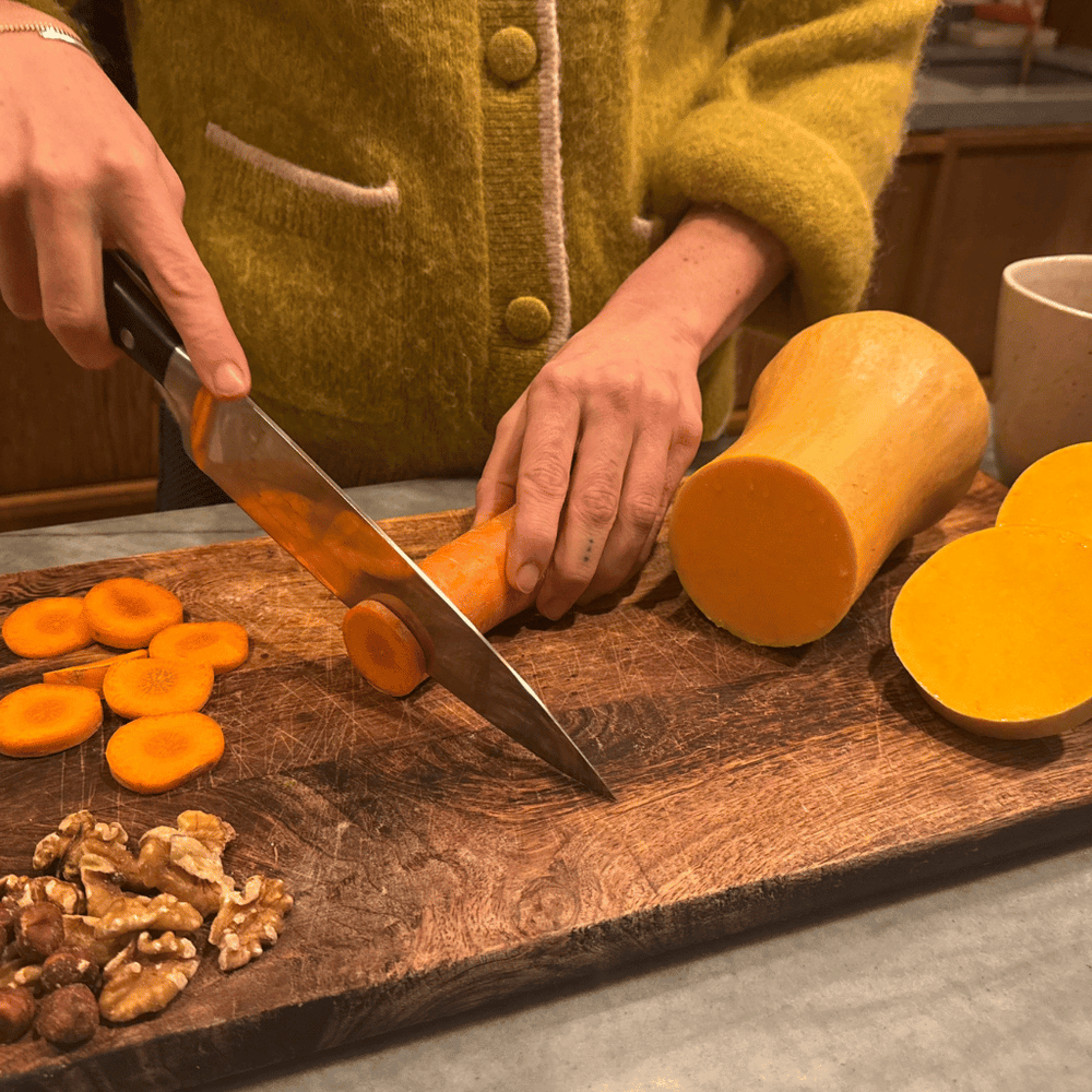 Cutting carrots, pumpkin and walnuts — autumn foods rich in beta-carotene and healthy fats that support glowing skin.