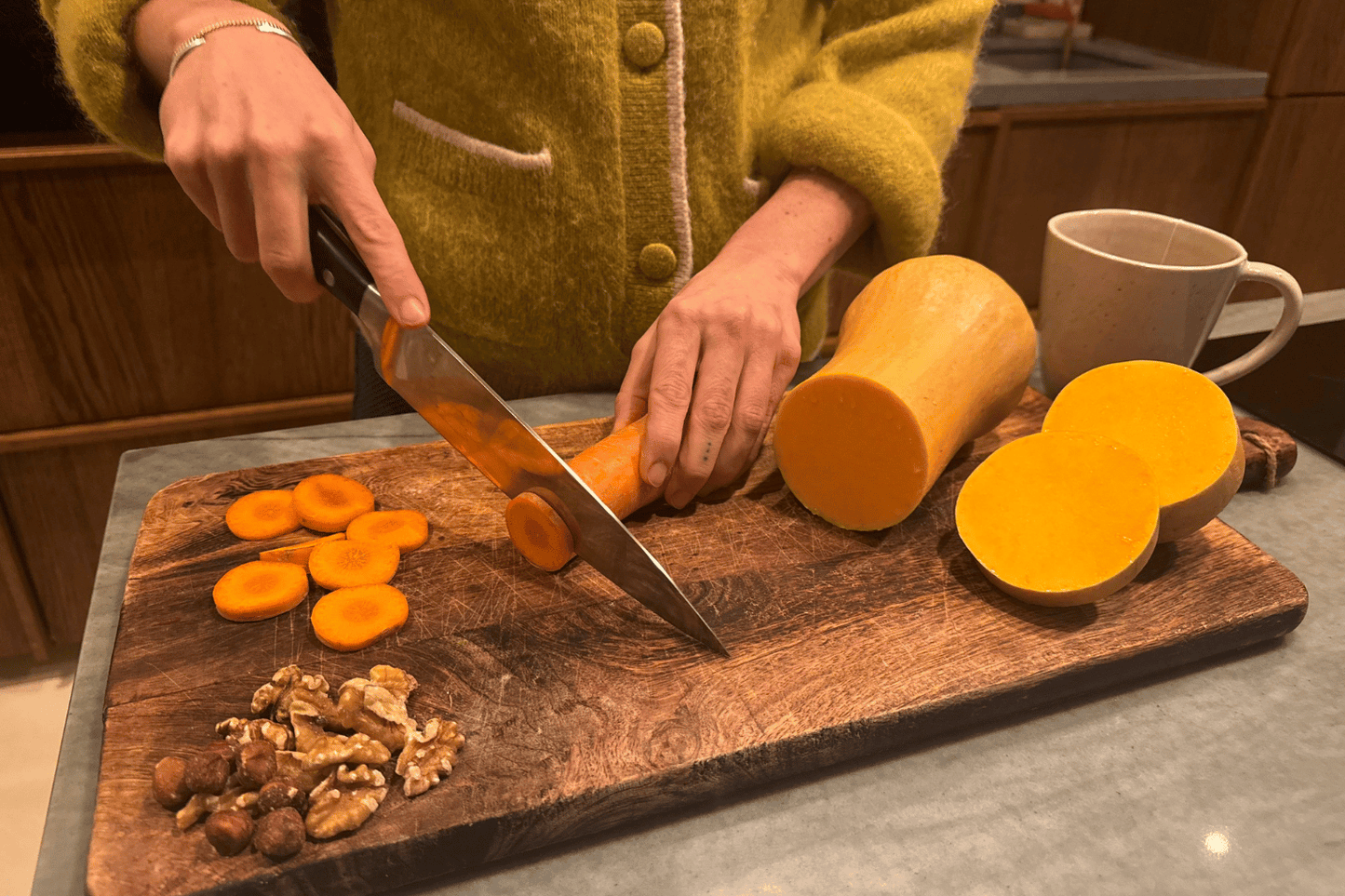 Cutting carrots, pumpkin and walnuts — autumn foods rich in beta-carotene and healthy fats that support glowing skin.